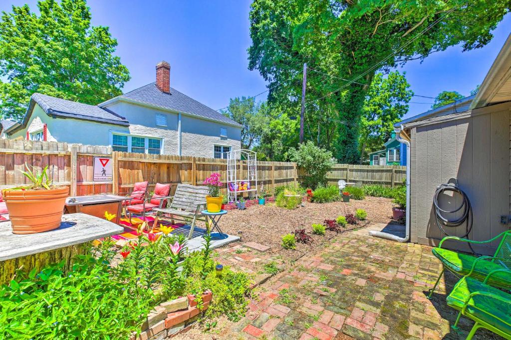 a backyard with a garden with chairs and a fence at Dtwn Elizabethtown Home with Fire Pit and Gas Grill! in Elizabethtown