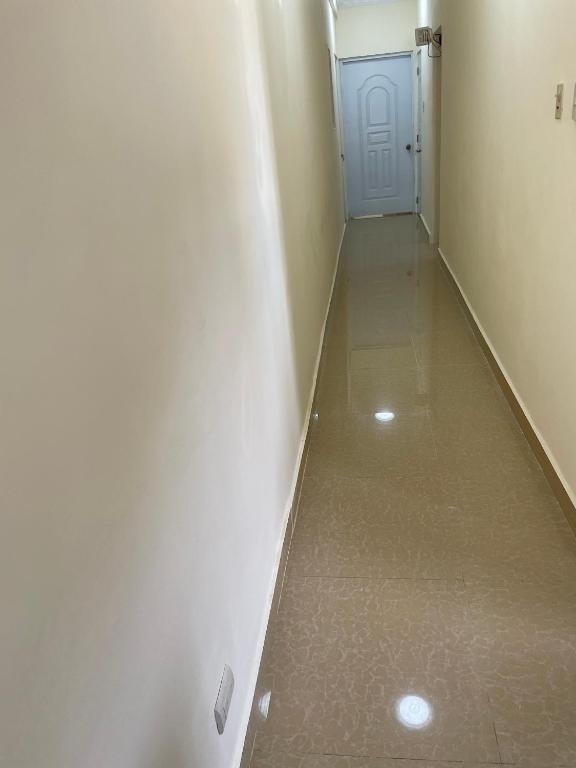 a hallway with a white wall and a blue door at Marbella1 in Los Frailes