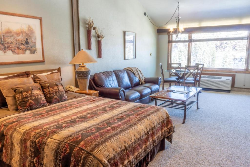 a bedroom with a bed and a couch and a table at Tamarron Lodge Loft 511 in Durango