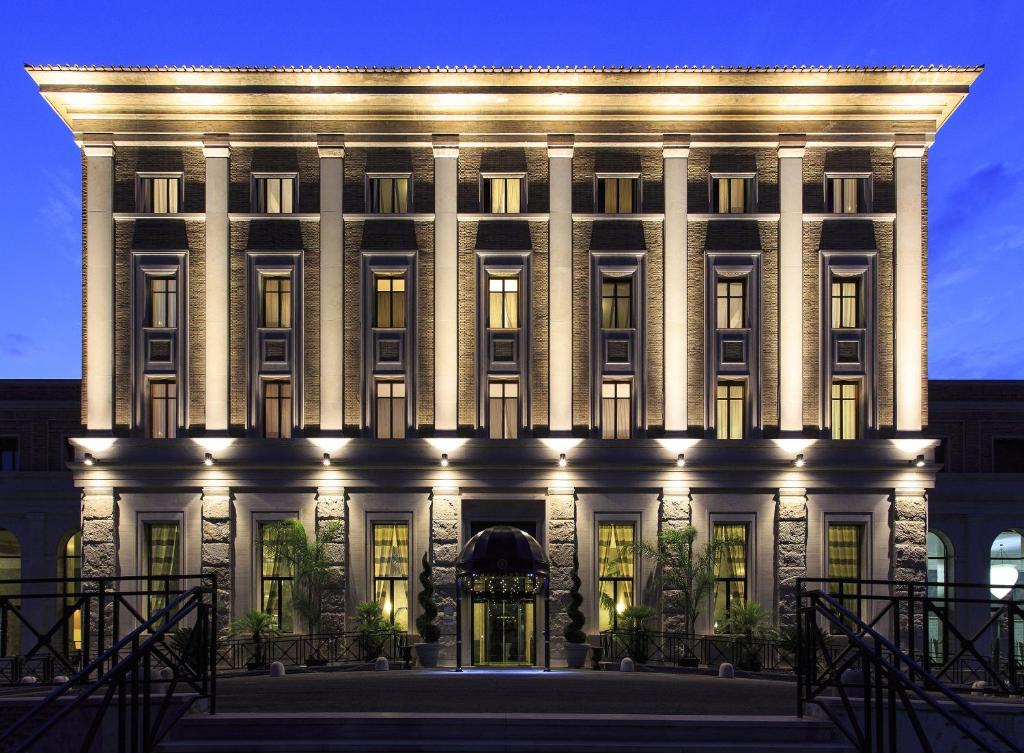 um grande edifício branco com luzes em TH Roma - Carpegna Palace em Roma