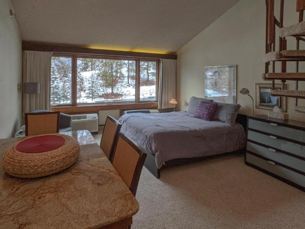 a bedroom with a bed and a table and a window at Tamarron Lodge Loft 210 in Durango