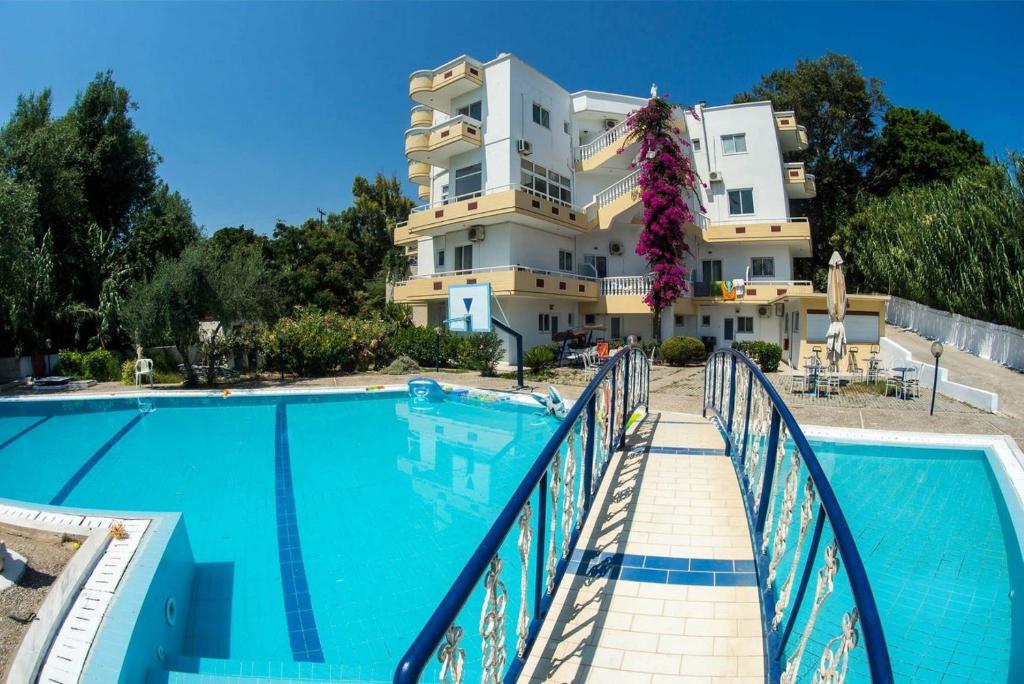 um hotel com piscina em frente a um edifício em Aphrodite Apartments em Kallithea, Rhodes
