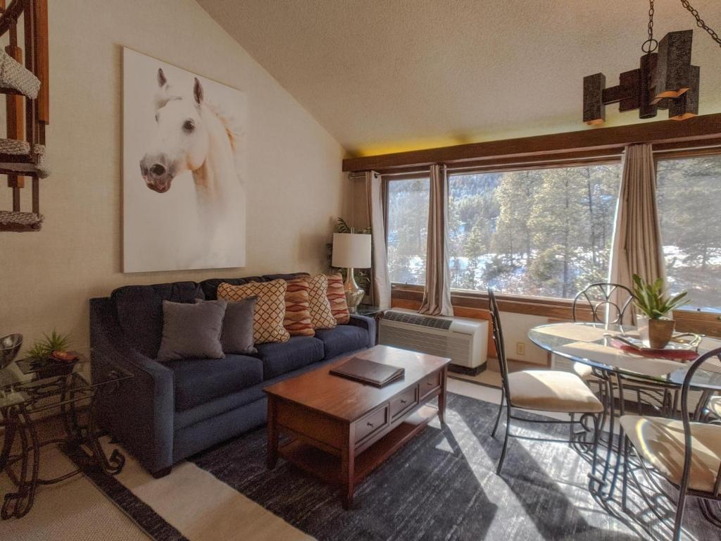 a living room with a blue couch and a horse on the wall at Tamarron Lodge Loft 314 in Durango
