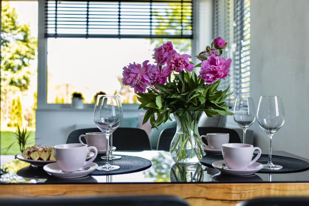 a table with a vase of purple flowers on it at Apartament Ogrodowy Zakątek in Uniejow