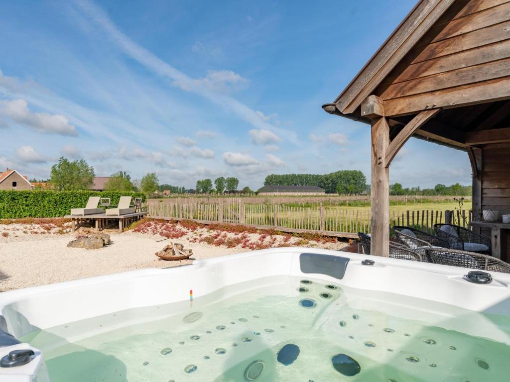 eine Whirlpool-Badewanne auf einer Terrasse im Hof in der Unterkunft Villa Noortem in Maldegem