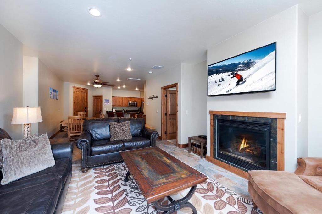 a living room with a couch and a fireplace at Peregrine Point 205 in Durango Mountain Resort