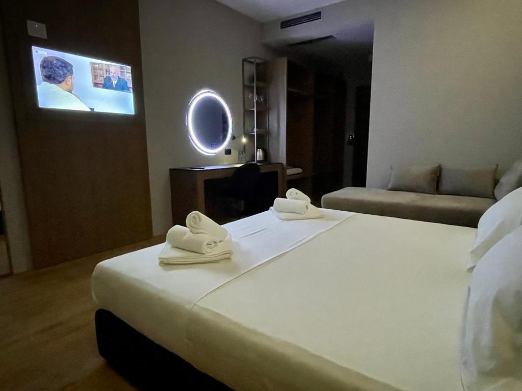 a hotel room with a bed and a tv at ELMAR HOTEL in Vlorë
