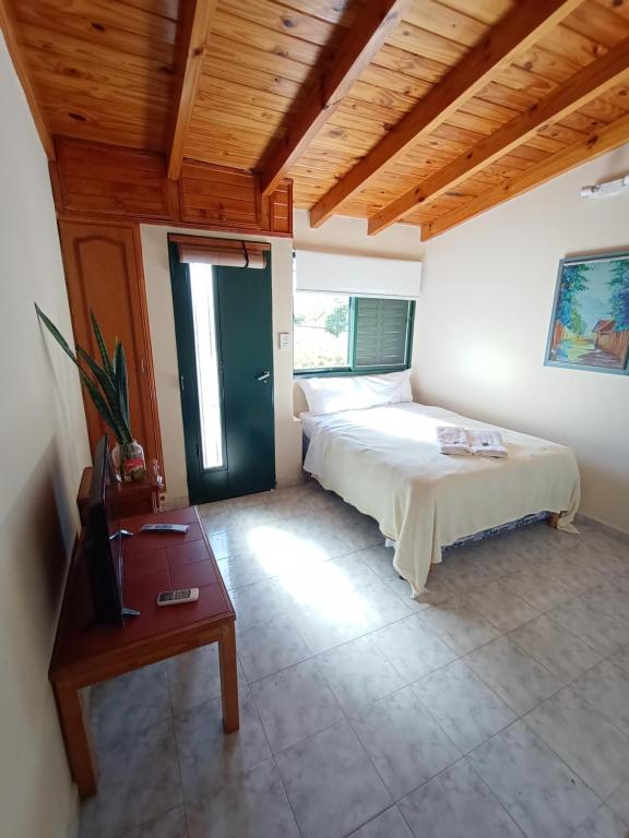 een slaapkamer met een bed en een houten plafond bij La Escalerita- Estadio Kempes in Cordoba