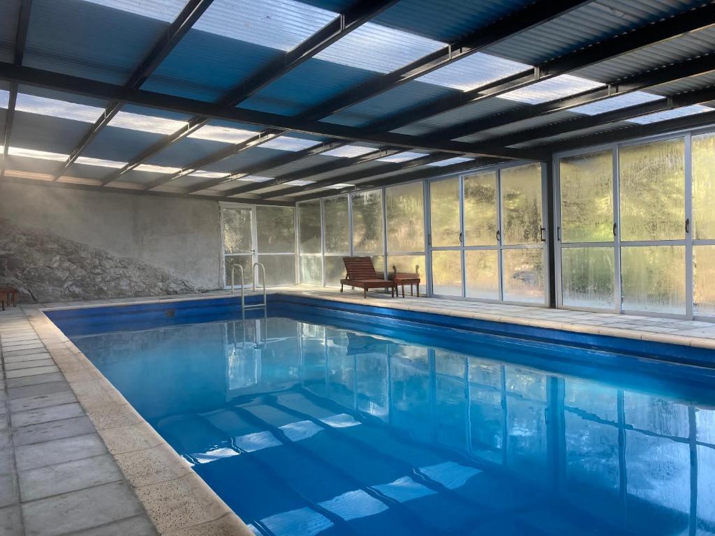 ein Pool mit blauem Wasser in einem Haus in der Unterkunft Cabañas El Tirol in La Falda