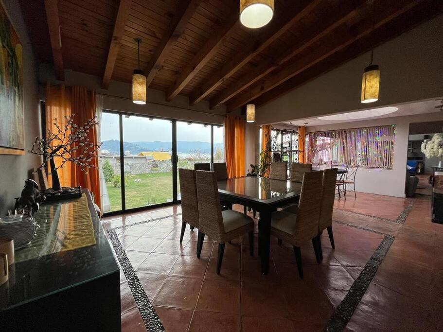 jadalnia ze stołem i krzesłami z widokiem w obiekcie Casa Valle Horus w mieście Valle de Bravo