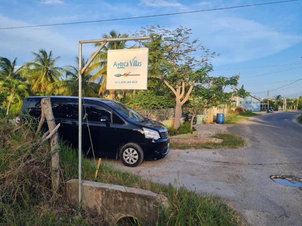 a car parked next to a sign on the side of a road at Azteca Villas in Treasure Beach