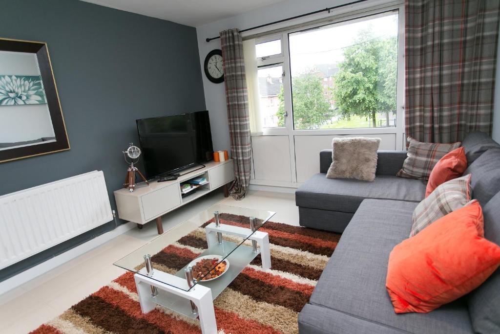 a living room with a couch and a tv at So-Cosy Cityside in Belfast
