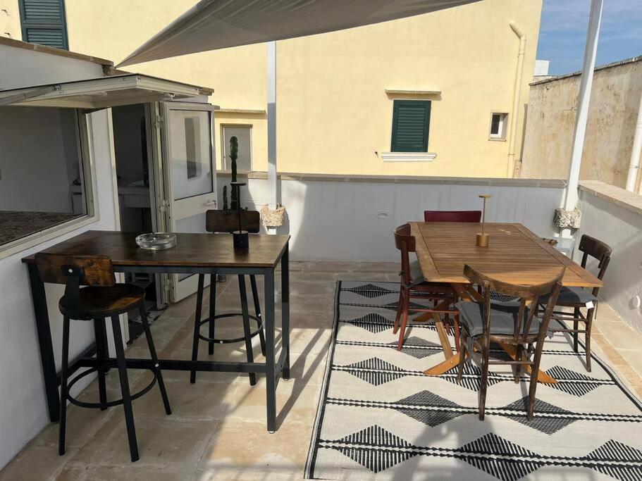 een patio met een houten tafel en stoelen en een tafel bij Casa Mignano in Gallipoli