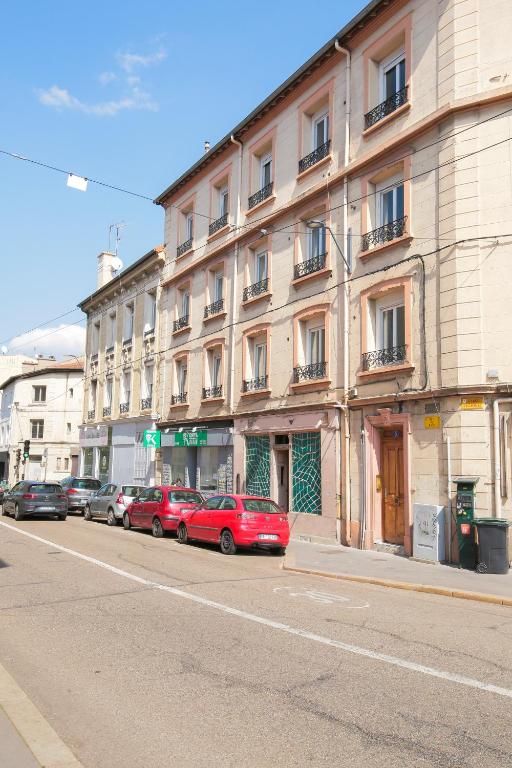 rząd samochodów zaparkowanych przed budynkiem w obiekcie Le Rhinocéros, T1 hypercentre chic et cosy, Wifi par SOVALFI w mieście Saint-Étienne