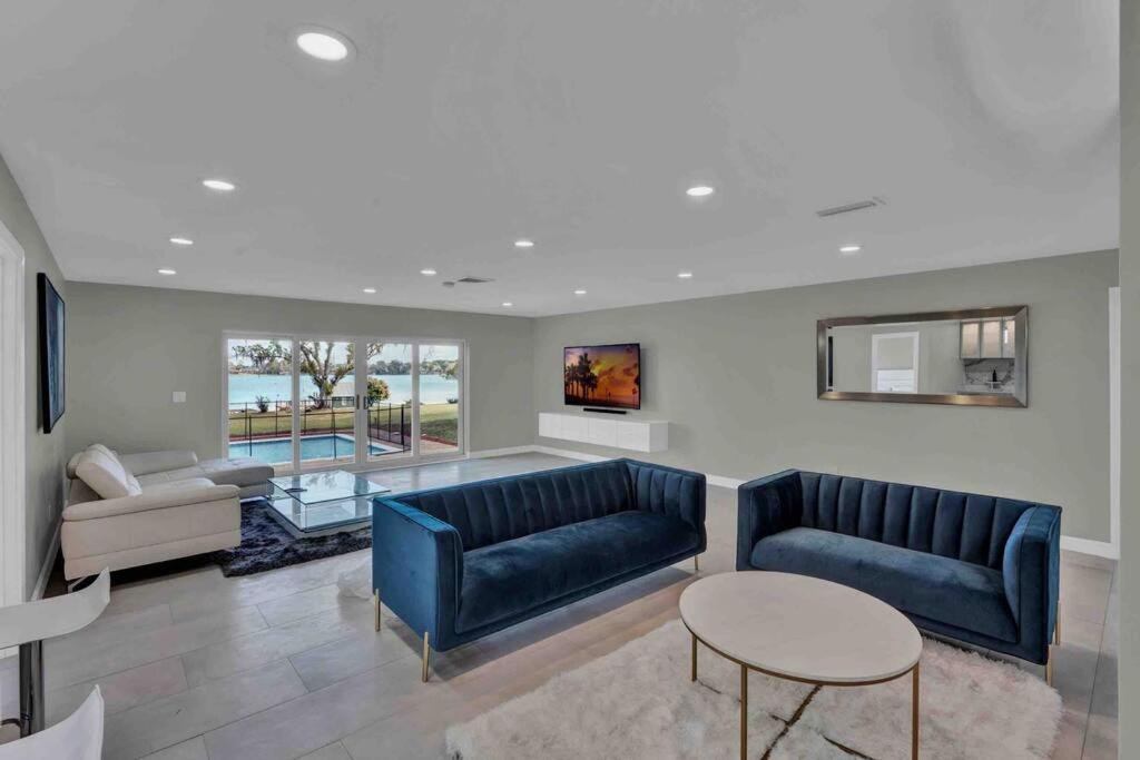 uma sala de estar com dois sofás azuis e uma mesa em Luxurious 5 bedroom lake house 3min from Universal em Orlando
