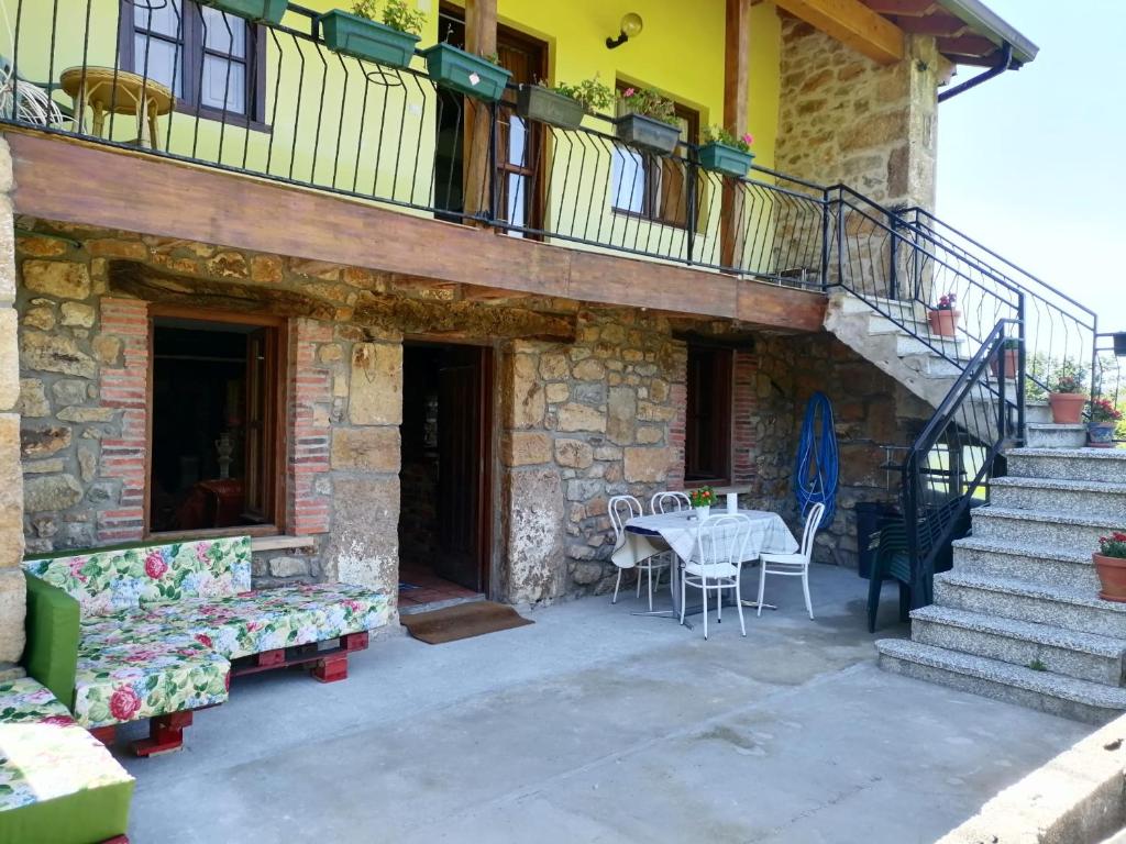eine Terrasse eines Hauses mit einem Tisch und Stühlen in der Unterkunft CASA RURAL EN RIAÑO-SOLORZANO in Santander