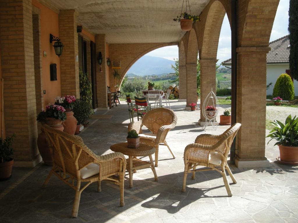 a patio with chairs and a table with a view at Bed And Breakfast San Martino in Castignano