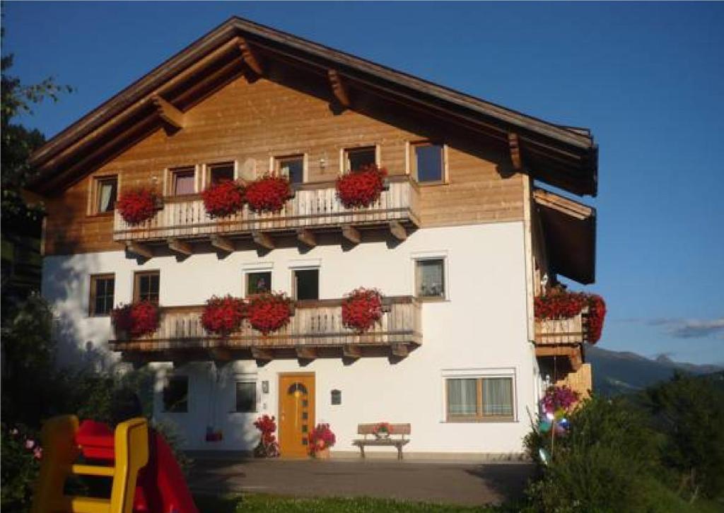 ein Haus mit einem Balkon mit Blumen darauf in der Unterkunft Steinerhof in Toblach