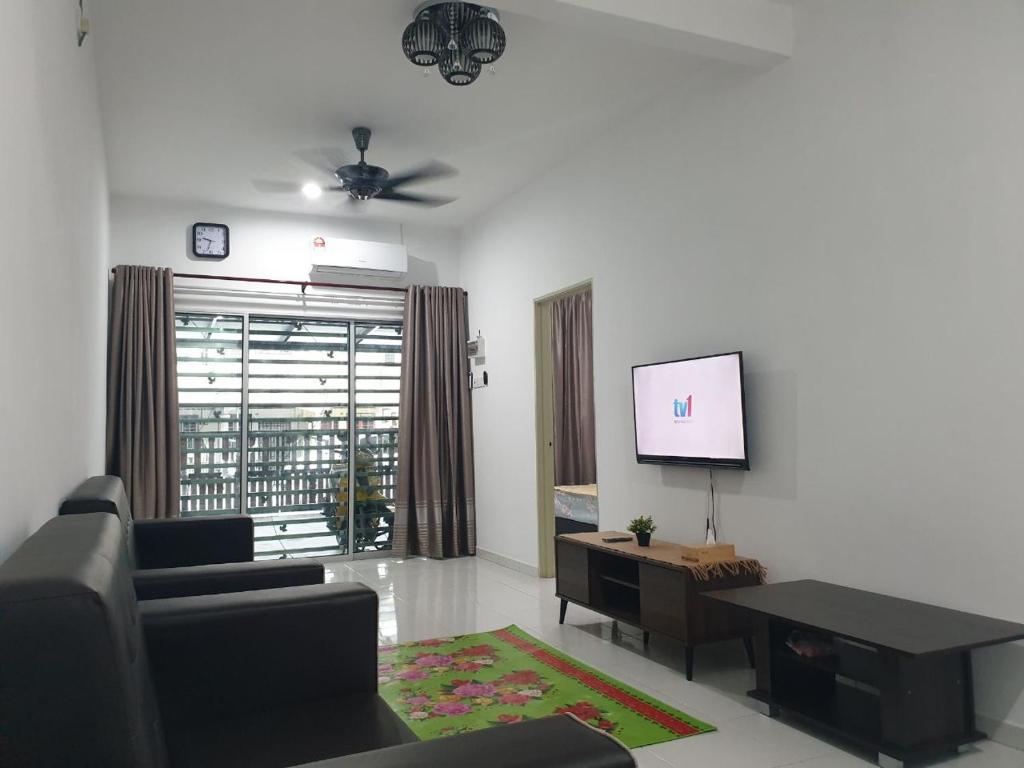 a living room with a couch and a flat screen tv at HOMESTAY IMPIAN QASEH MANJUNG (MUSLIM) in Seri Manjung