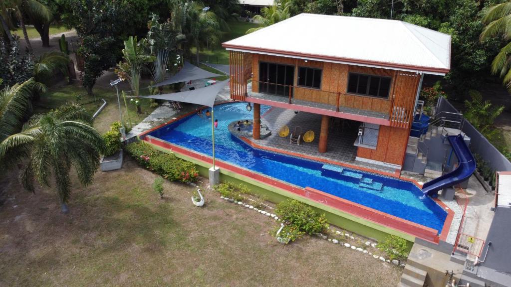 Cette chambre offre une vue sur une maison dotée d'une piscine. dans l'établissement Shenanigans Glamping Resort, à Zamboanguita