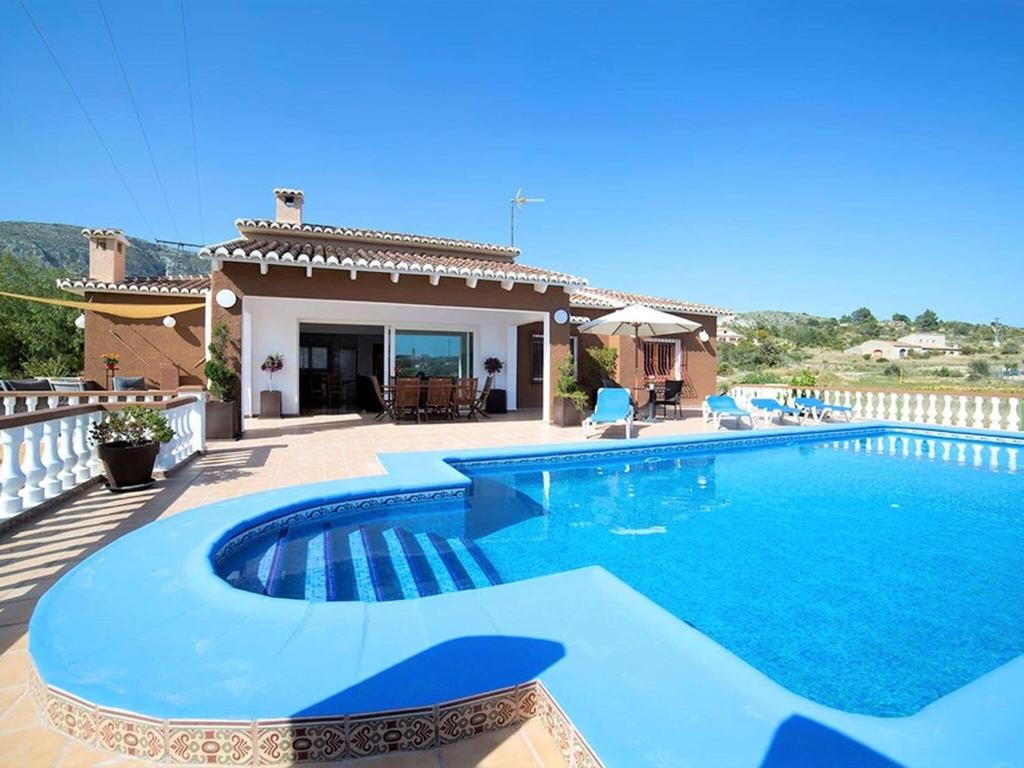 a swimming pool in front of a house at Spacious Home in Teulada in Teulada