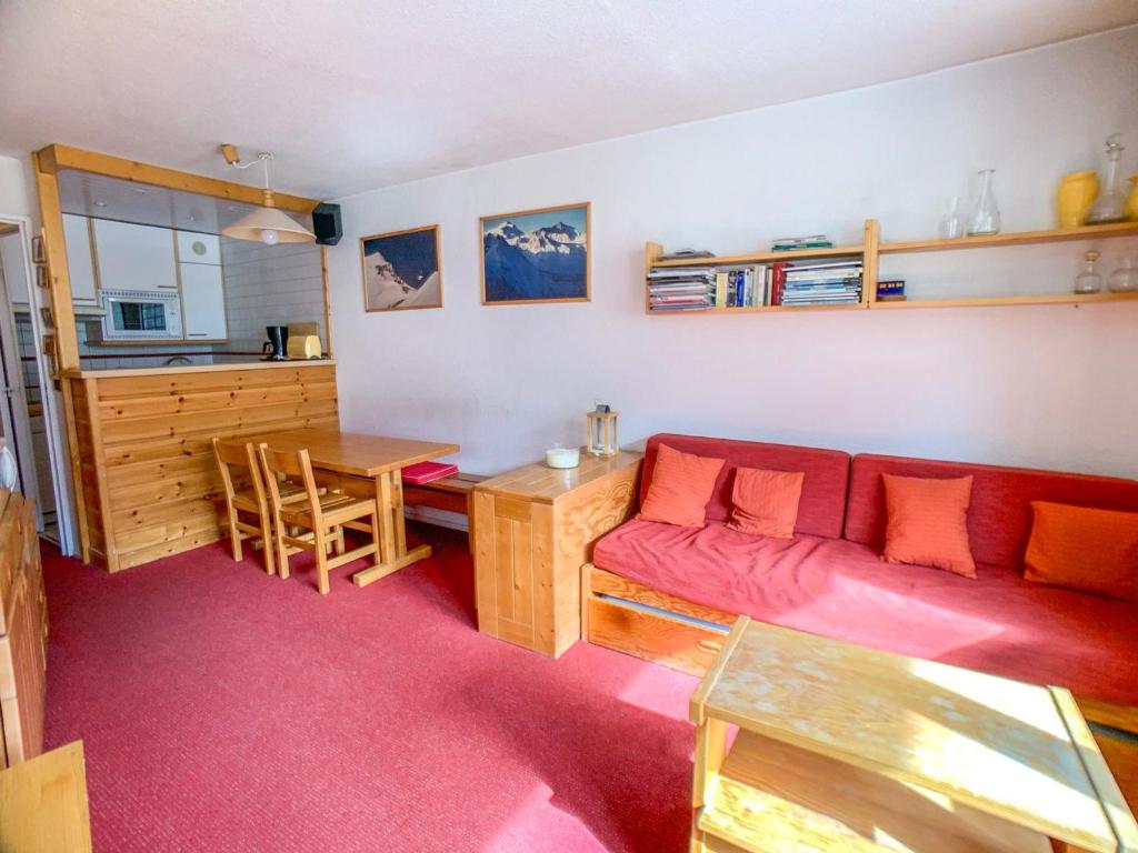 a living room with a red couch and a table at Appartement Tignes, 2 pièces, 6 personnes - FR-1-502-288 in Tignes