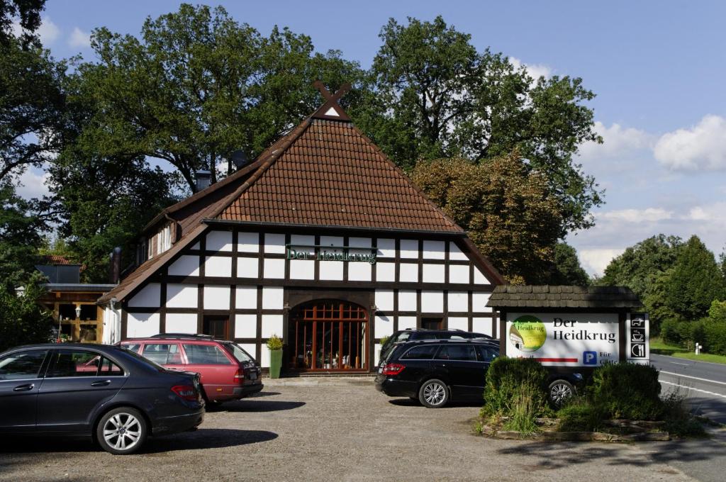a black and white building with cars parked in front at Der Heidkrug in Verden