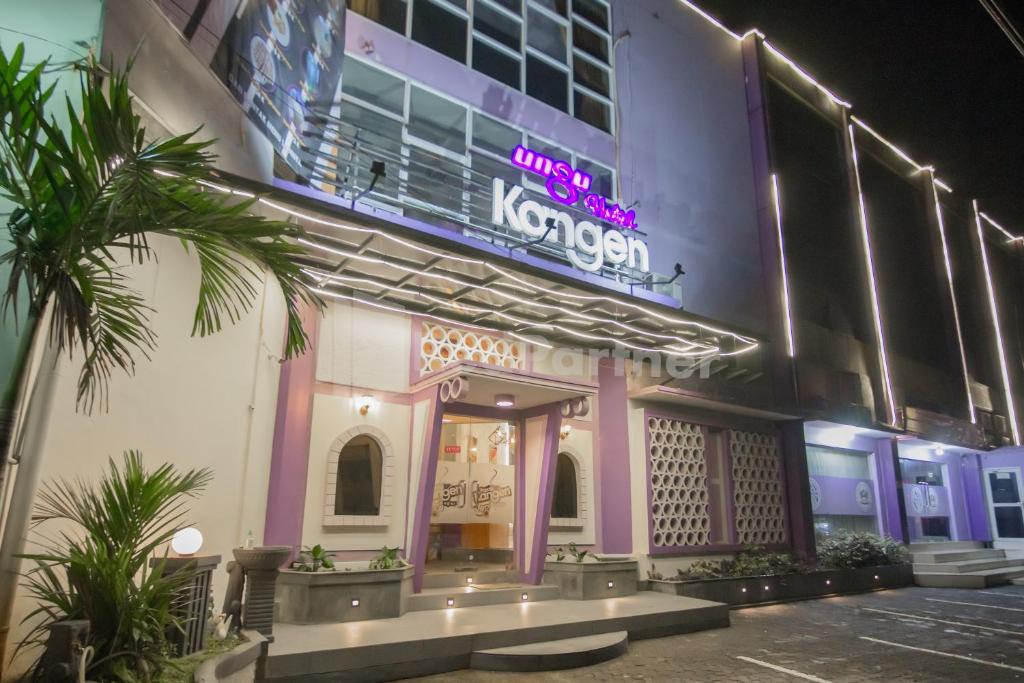 ein Gebäude mit einem Neonschild auf der Seite in der Unterkunft Ungu Kangen Hotel Bogor Mitra RedDoorz in Bogor
