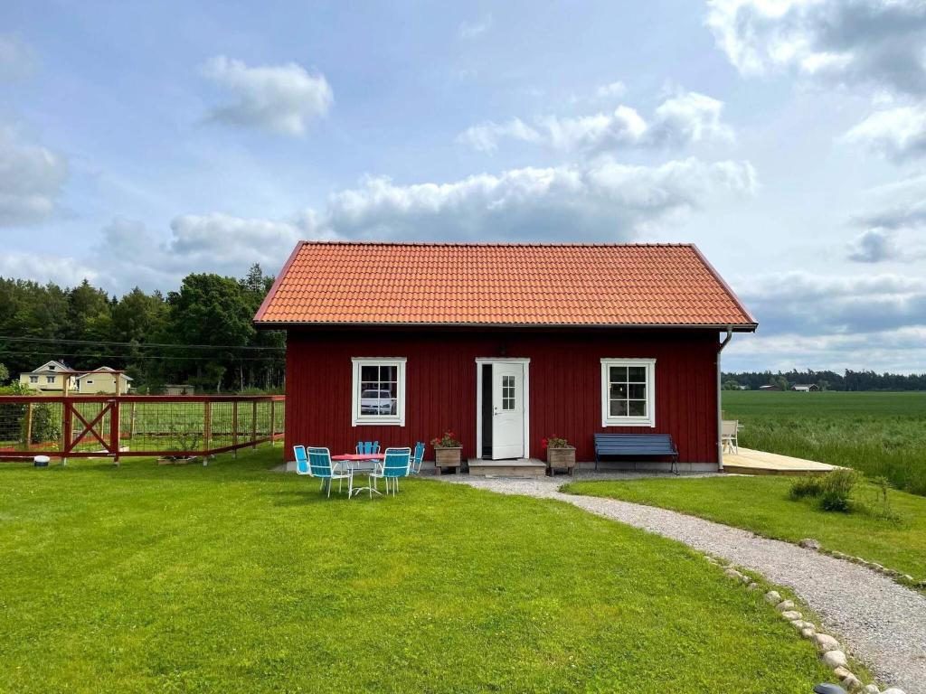 een rood huis met een tafel en stoelen in de tuin bij 6 person holiday home in GÖTENE-By Traum in Götene