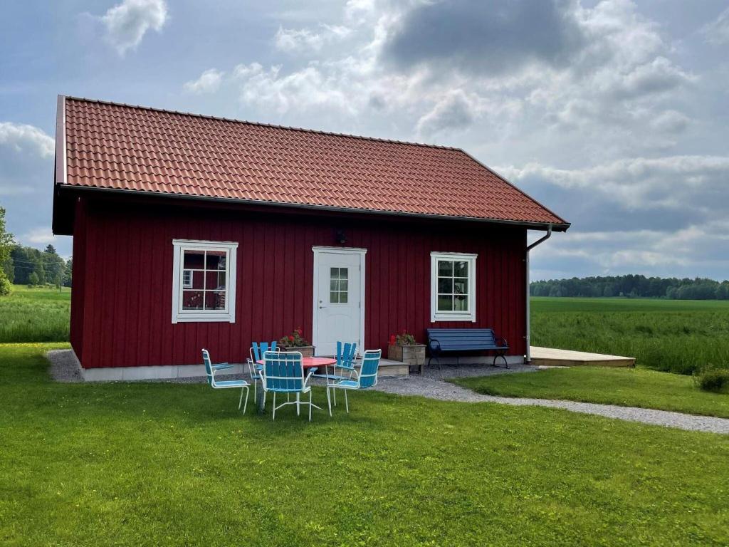 a red house with a table and chairs in front of it at Holiday home GÖTENE II in Götene