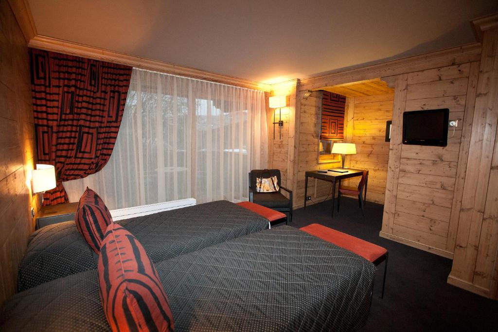 a hotel room with two beds and a window at Hotel Le Samoyede in Morzine