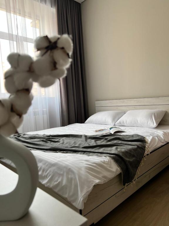 um quarto com uma cama com um urso de peluche em Green Plaza - ЖК Грин Плаза em Aktau