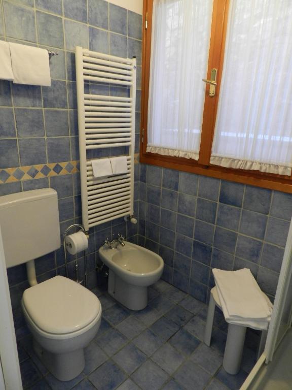a blue tiled bathroom with a toilet and a sink at Hotel Punta Mesco in Monterosso al Mare