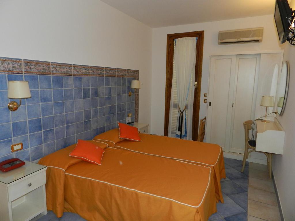 a bedroom with a large orange bed with orange pillows at Hotel Punta Mesco in Monterosso al Mare