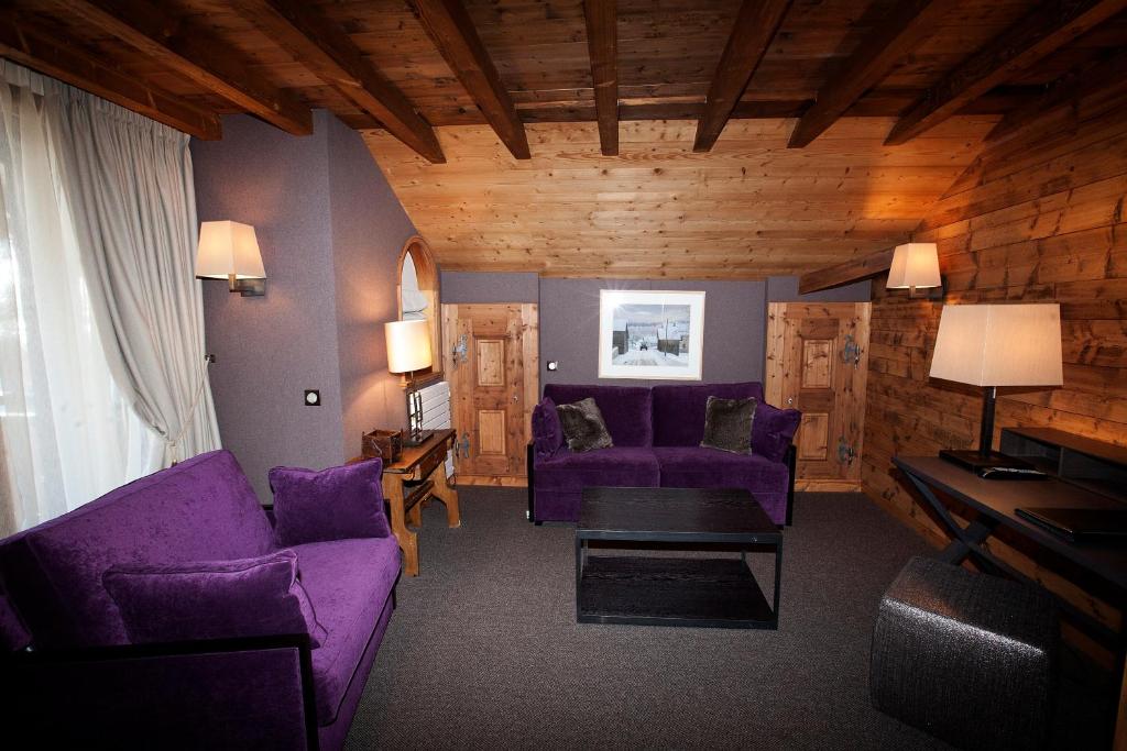 a living room with purple chairs and a purple couch at Hotel Le Samoyede in Morzine