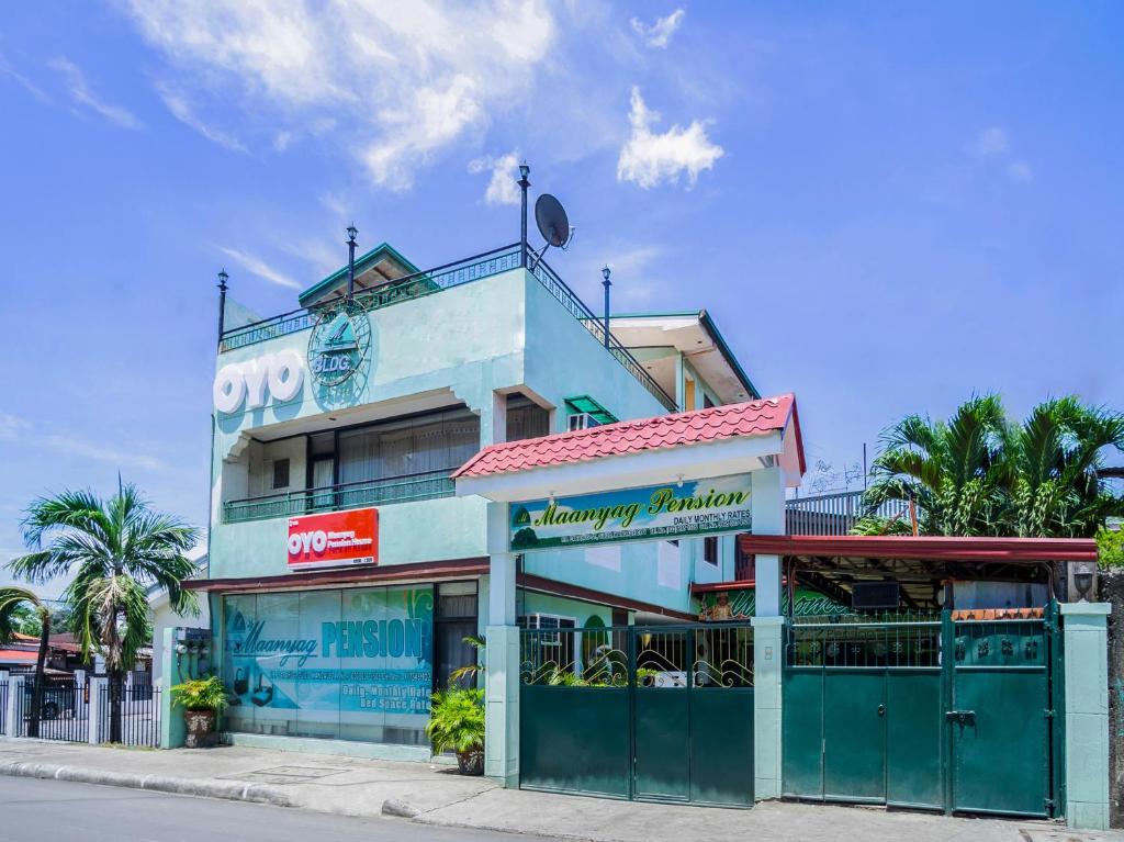 un bâtiment bleu avec un restaurant dans la rue dans l'établissement OYO 166 Maanyag Pension House, à Cebu