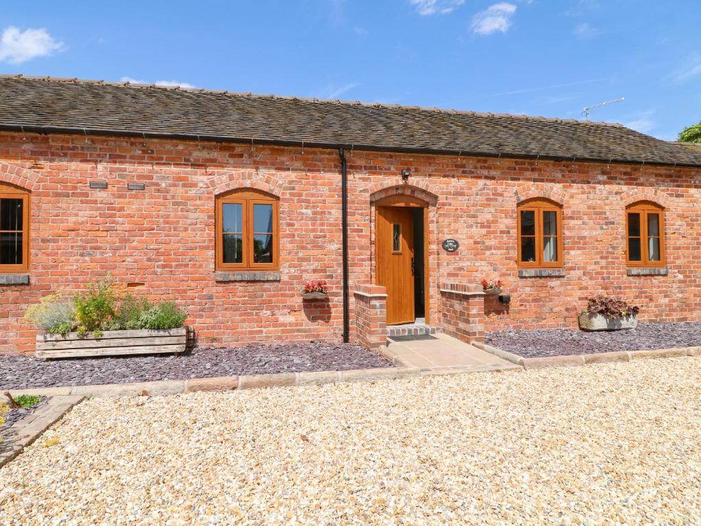 a red brick building with a brown door at Robin's Rest in Stoke on Trent