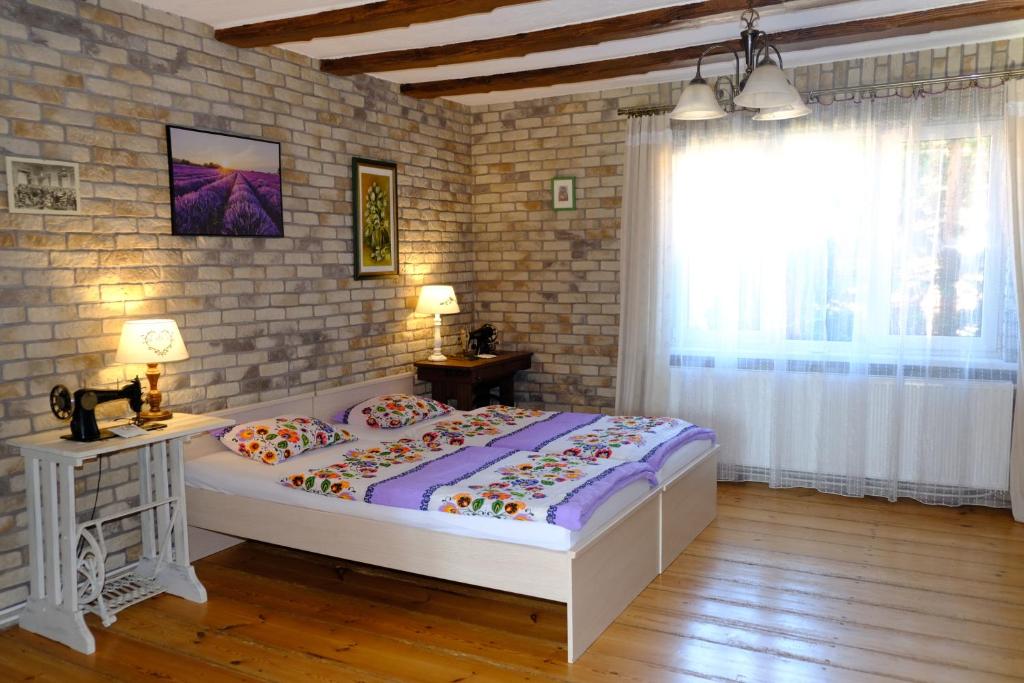 1 dormitorio con 1 cama grande y pared de ladrillo en Siedlisko Egniu Agroturystyka nad jeziorem Pojezierze Drawskie, en Żabinek