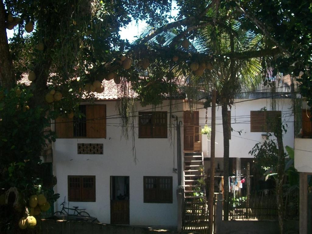 Casa blanca con ventanas de madera y puerta en Casa da Jaca 02, en Itacaré