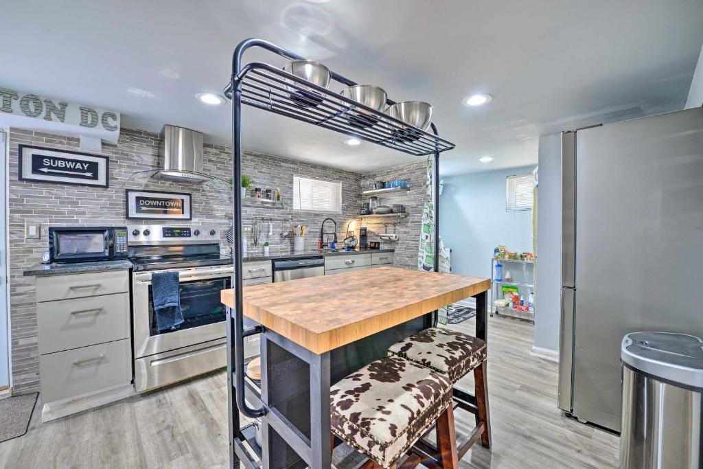 a kitchen with a table and a refrigerator at Stylish DC Studio about 5 Mi to National Mall! in Washington