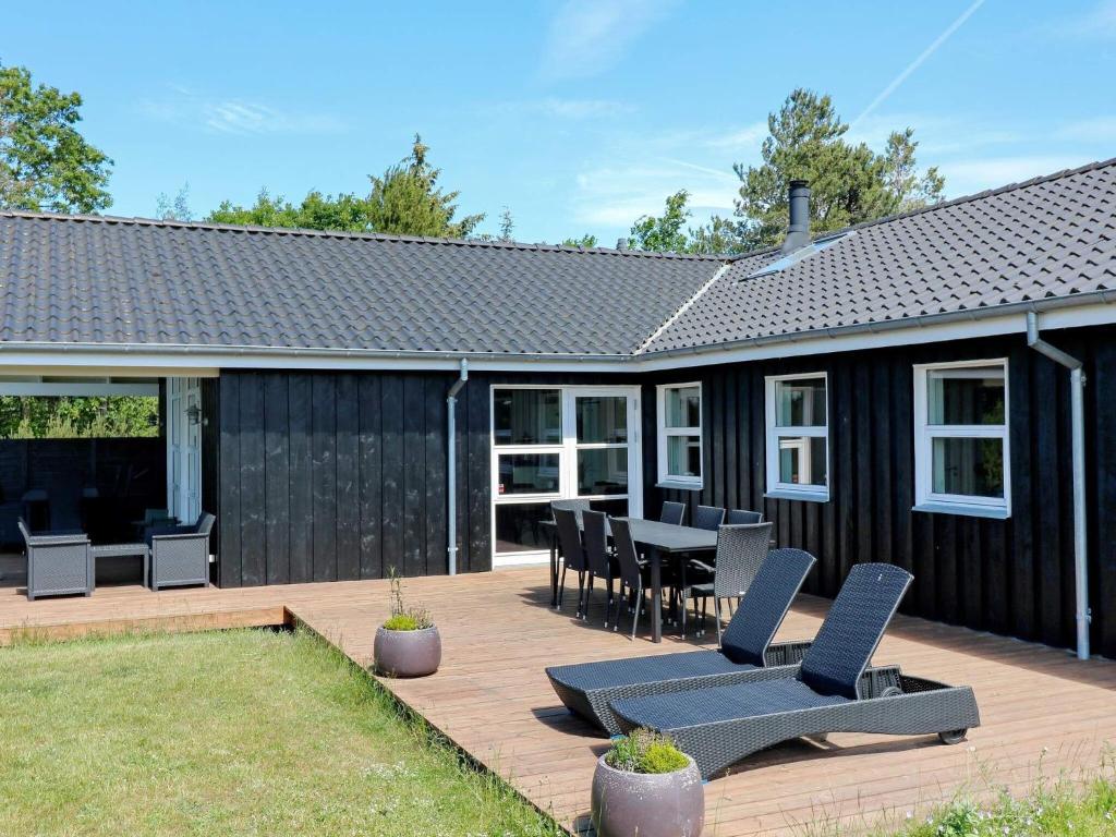 um pátio com cadeiras, uma mesa e uma casa em 10 person holiday home in Hadsund em Hadsund