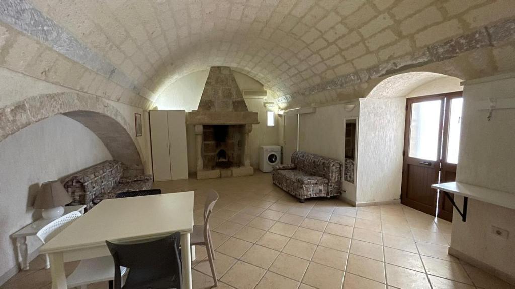 a living room with a table and a fireplace at Corte nel borgo in Minervino di Lecce