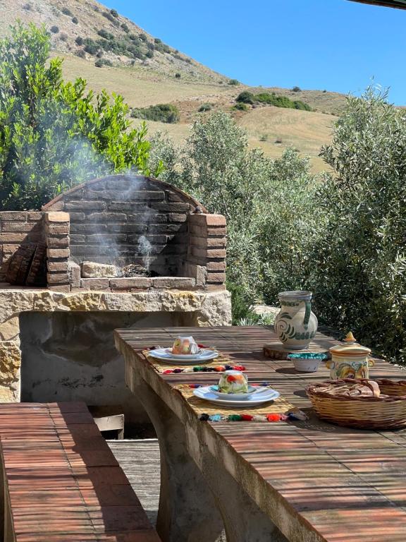 una mesa con platos de comida en una terraza con parrilla en Casale Etna Testa di Moro, 
