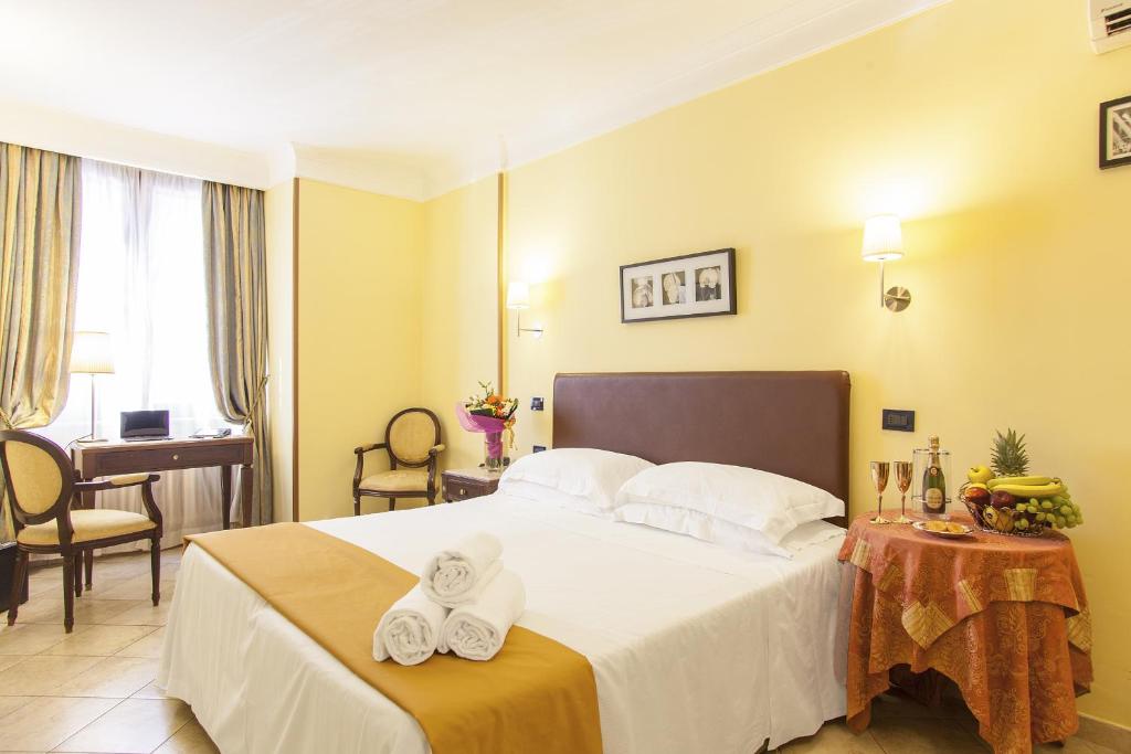 Hotel Tuscolana في روما: غرفة فندق عليها سرير وفوط
