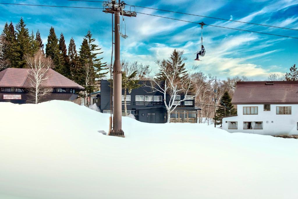 a person on a ski lift in the snow at SKI INN HAKUBA in Otari