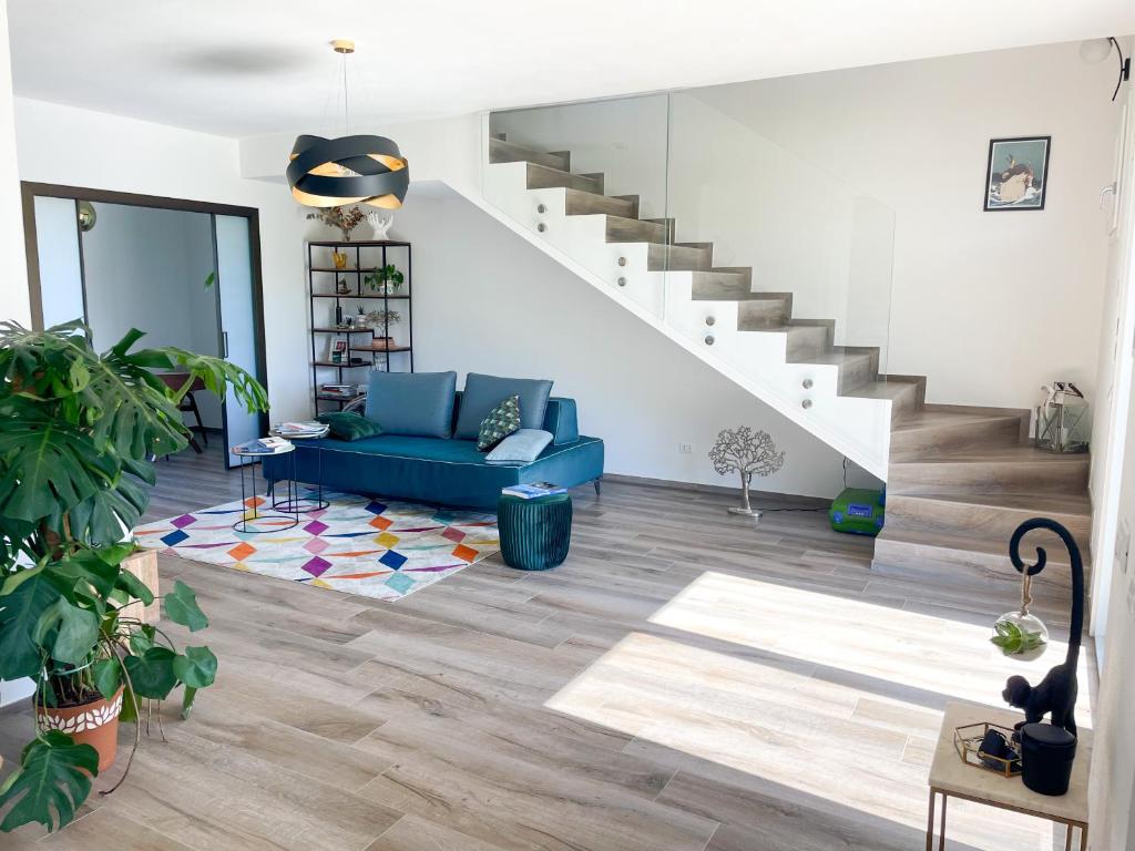 ein Wohnzimmer mit einem blauen Sofa und einer Treppe in der Unterkunft Casa moderna per vacanze rilassanti in San Martino in Fiume