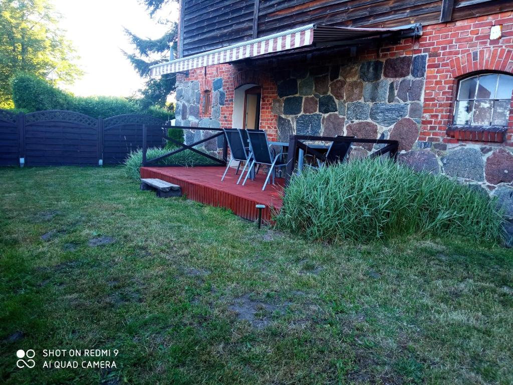 une maison avec 2 chaises et une table sur une terrasse couverte dans l'établissement P-4, à Retowo