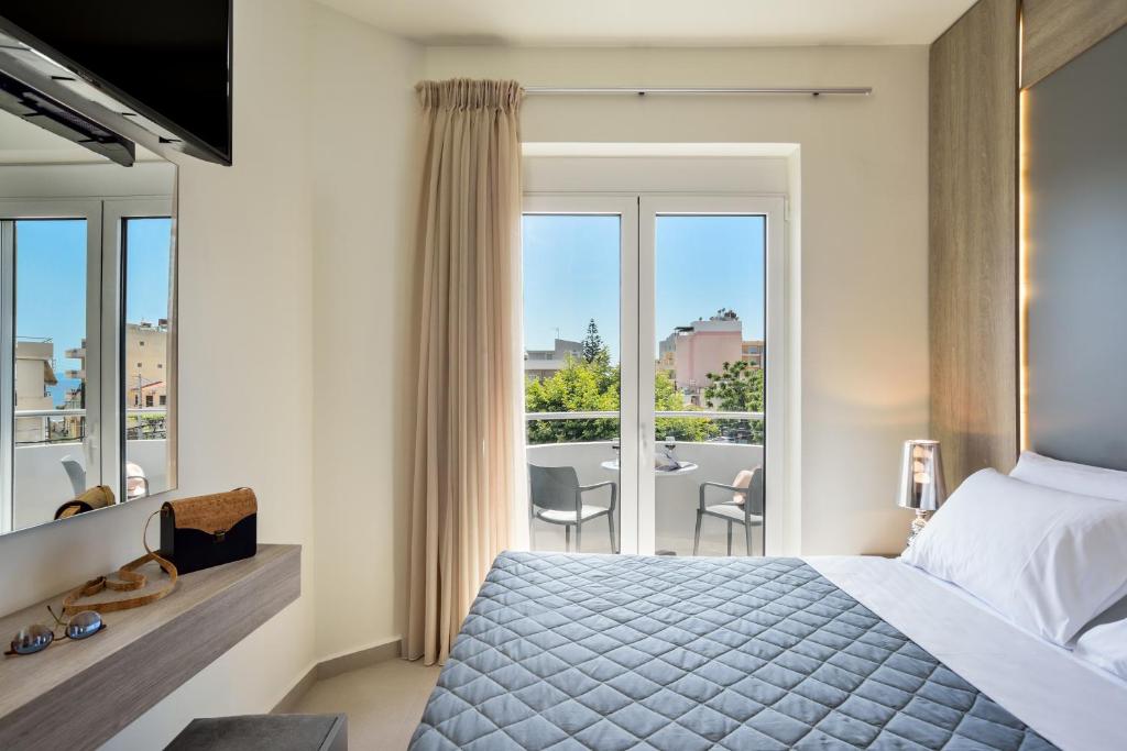 sypialnia z łóżkiem i balkonem ze stołem w obiekcie Elia Residences w Chanii
