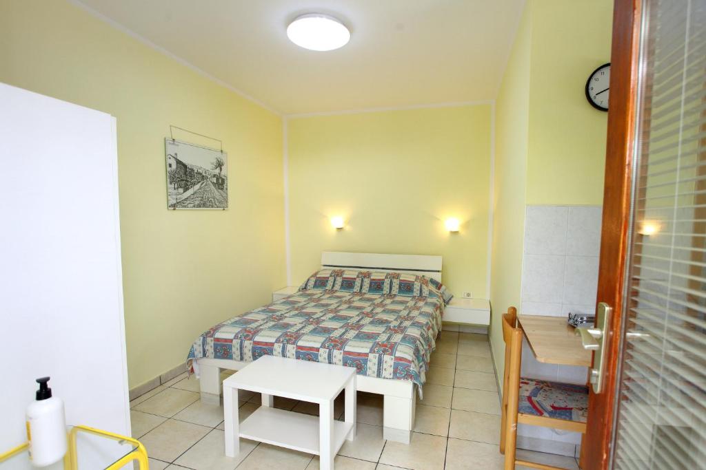 een kleine slaapkamer met een bed en een tafel bij DINO Studio and Room Apartments in Portorož