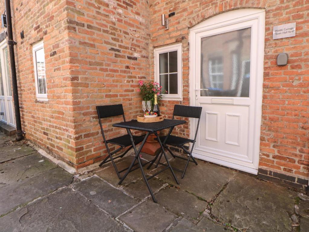 een tafel en twee stoelen voor een deur bij Middle Cottage in Ashbourne